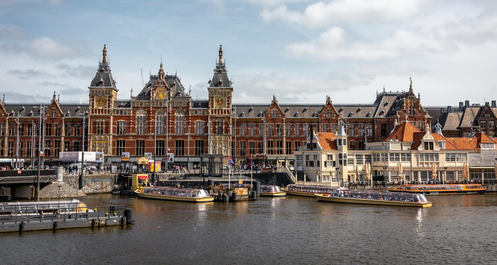 The impressive Amsterdam Centraal railway station with its neo-Renaissance architecture and bustling platforms.
